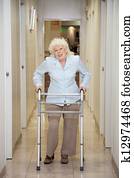 Elderly Woman With Walker In Hospital Corridor