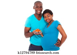 expecting couple holding baby shoes