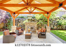 Exterior covered patio with fireplace and furniture. Exterior covered patio with fireplace and furniture.
