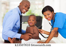 female nurse examining little boy with male doctor
