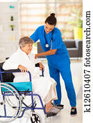 friendly caregiver helping senior woman