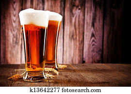 Glasses of beer on wooden table Glasses of beer on wooden table