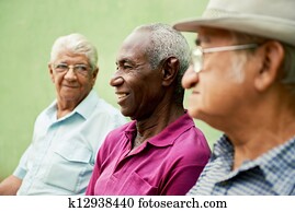 Group of old black and caucasian men talking in park