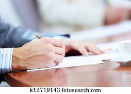Hands of businessman writing