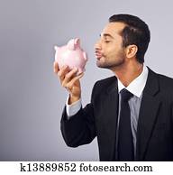 Handsome Executive Kissing a Coin Bank Handsome Executive Kissing a Coin Bank