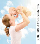 happy family. Mother kissing baby in the sky