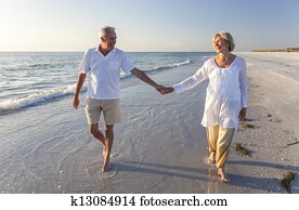 Happy Senior Couple Walking Holding Hands Tropical Beach