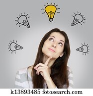 Happy thinking woman looking up on idea yellow bulb. Inspiration concept on grey background Happy thinking woman looking up on idea yellow bulb. Inspiration concept on grey background