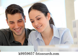 Happy young couple signing property purchase contract 