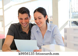 Happy young couple signing property purchase contract 