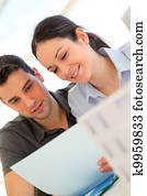 Happy young couple signing property purchase contract 