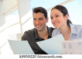 Happy young couple signing property purchase contract 