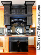 Kitchen island and stove custom wood cabinets. New luxury home interior.