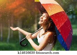 Laughing woman with umbrella checking for rain Laughing woman with umbrella checking for rain