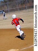 Little league baseball player running bases