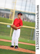 Little league pitcher in red looking.