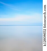 Long exposure photography. Horizon line, soft sea and blue sky