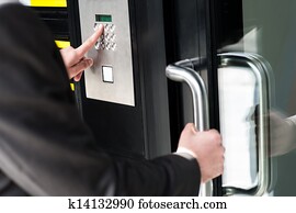 Man entering security code to unlock the door Man entering security code to unlock the door