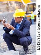 mine manager inspecting ore