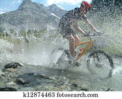 Mountain biker riding through river bed