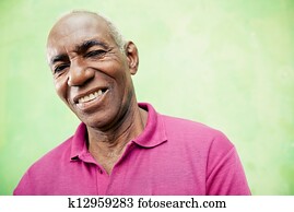 Portrait of elderly black man looking and smiling at camera
