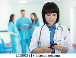 Portrait of female doctor with interns in background