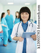 Portrait of female doctor with interns in background