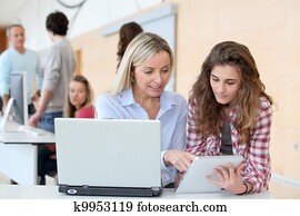 Portrait of teacher and teenage girl in computing class