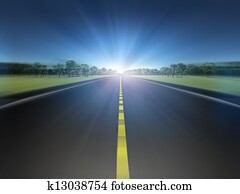 Road in green landscape moving toward light Road in green landscape moving toward light
