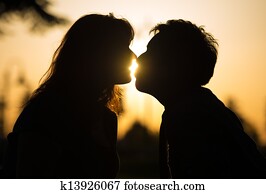 Romantic couple kissing at sunset Romantic couple kissing at sunset