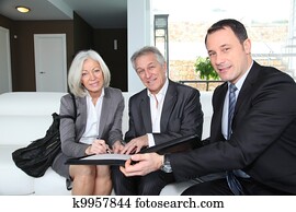 Senior couple signing financial contract for property purchase