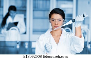 Serious chemist working with large pipette and test tube