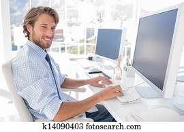 Smiling designer working at his desk Smiling designer working at his desk