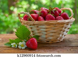 Strawberries in basket on garden table Strawberries in basket on garden table