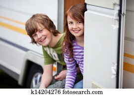 Two Kids Sitting In Doorway Of RV Two Kids Sitting In Doorway Of RV