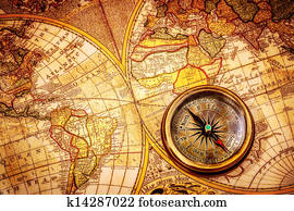 Vintage compass lies on an ancient world map. Vintage compass lies on an ancient world map.