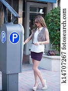 Well dressed women at a parking meter