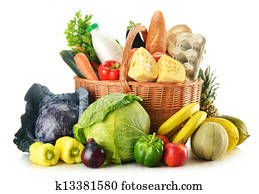 Wicker basket with variety of grocery products isolated on white