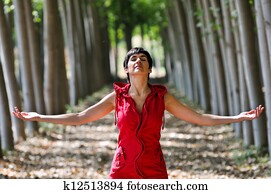 Woman dressed in red, meditating in the forest