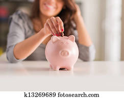 Woman Putting Coin In Piggy Bank Woman Putting Coin In Piggy Bank