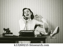 Woman talking on phone at desk Woman talking on phone at desk