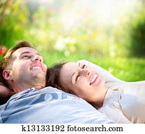 Young Couple Lying on Grass Outdoor 
