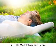 Young Couple Lying on Grass Outdoor