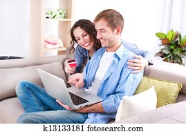 Young couple with Laptop and Credit Card buying online