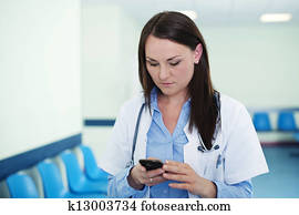 Young female doctor texting