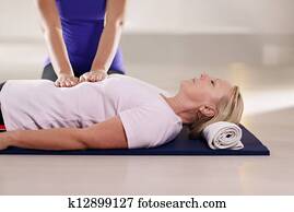 Young therapist doing reiki therapy to senior woman Young therapist doing reiki therapy to senior woman