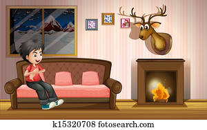 A boy sitting at the sofa near the fireplace A boy sitting at the sofa near the fireplace