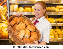 Baker in bakery with basket full of bread Baker in bakery with basket full of bread