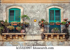 Beautiful vintage balcony with colorful flowers and doors Beautiful vintage balcony with colorful flowers and doors