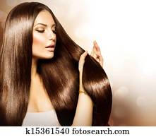 Beauty Woman touching her Long and Healthy Brown Hair